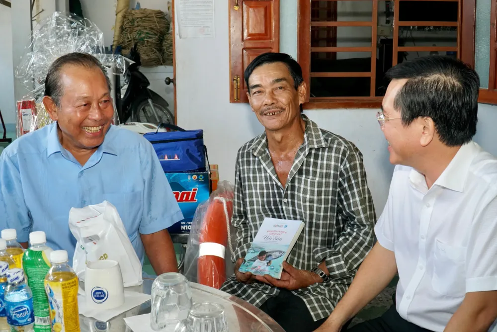 Nguyên Phó Thủ tướng Thường trực Trương Hoà Bình (ngoài cùng trái) trò chuyện với ngư dân Nguyễn Văn Ngộ. Ảnh: BẢO PHƯƠNG