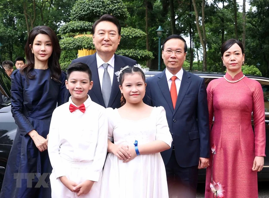 Chủ tịch nước Võ Văn Thưởng và Phu nhân cùng Tổng thống Hàn Quốc Yoon Suk Yeol và Phu nhân với thiếu nhi Thủ đô tại lễ đón. Ảnh: TTXVN