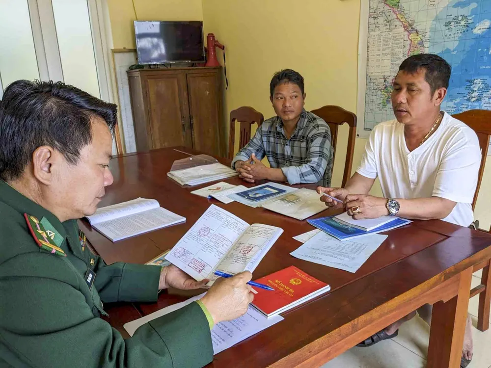 Các chiến sĩ Đồn Biên phòng cửa khẩu cảng Cửa Việt, BĐBP Quảng Trị tuyên tuyền cho ngư dân về chống khai thác IUU trong thời điểm người dân đăng ký xuất nhập lạch. Ảnh: NGUYỄN DO