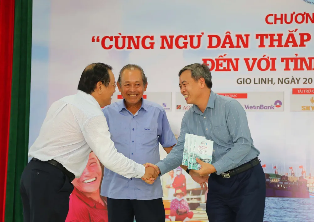 Ông Mai Ngọc Phước, Tổng biên tập báo Pháp Luật TP.HCM, đã thông tin về ý nghĩa, quy mô của chương trình &quot;Cùng ngư dân thắp sáng đèn trên biển&quot; và bày tỏ mong mỏi các ngư dân vượt khó vươn khơi, bám biển an toàn, giới thiệu về cuốn cẩm nang &quot;Những điều cần biết về đánh bắt hải sản” do báo Pháp Luật TP.HCM chủ biên để các ngư dân hiểu luật, đánh bắt hải sản đúng luật, chung tay cùng cả nước gỡ thẻ vàng hải sản của Ủy ban châu Âu (EC). Trong ảnh: Ban Tổ chức trao tượng trưng cho tỉnh Quảng Trị 200 cuốn cẩm nang “Những điều cần biết về đánh bắt hải sản”. Ảnh: HOÀNG GIANG