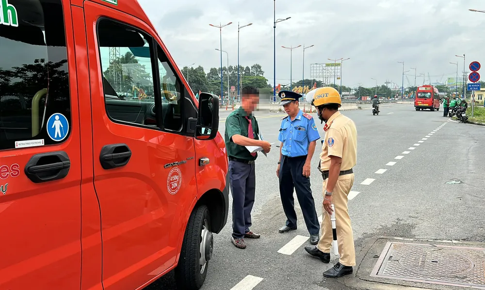 Tổ công tác kiểm tra giấy tờ đối với một xe khách trước bến xe miền Đông mới.