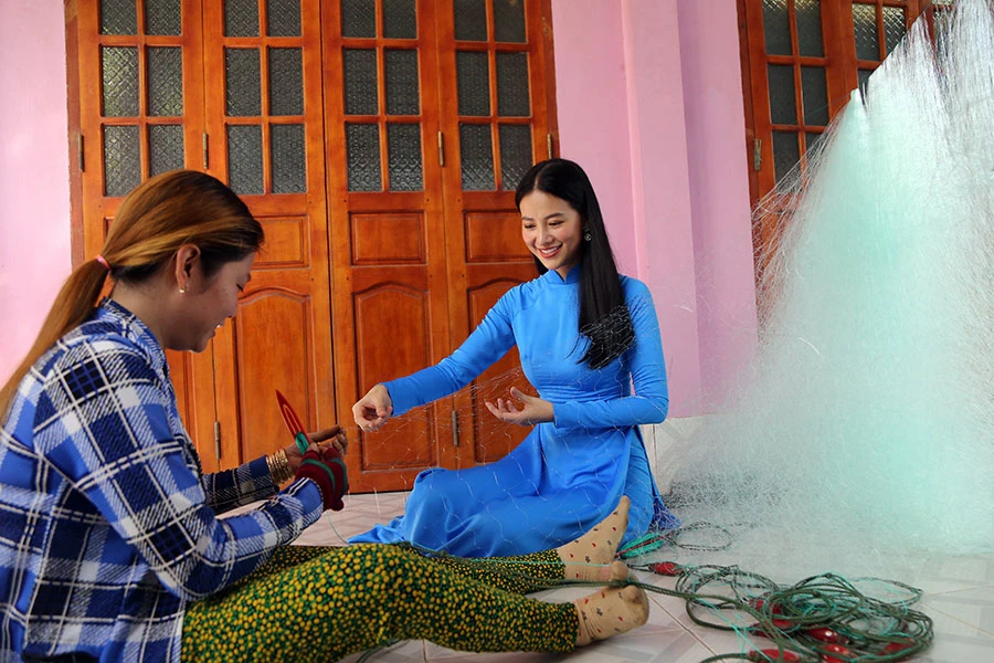 Hoa hậu Nguyễn Phương Khánh, đại sứ chương trình “Cùng ngư dân thắp sáng đèn trên biển”, trải nghiệm đan lưới cùng ngư dân. Ảnh: HOÀNG GIANG p23-anh-mau-8334-2852.jpg