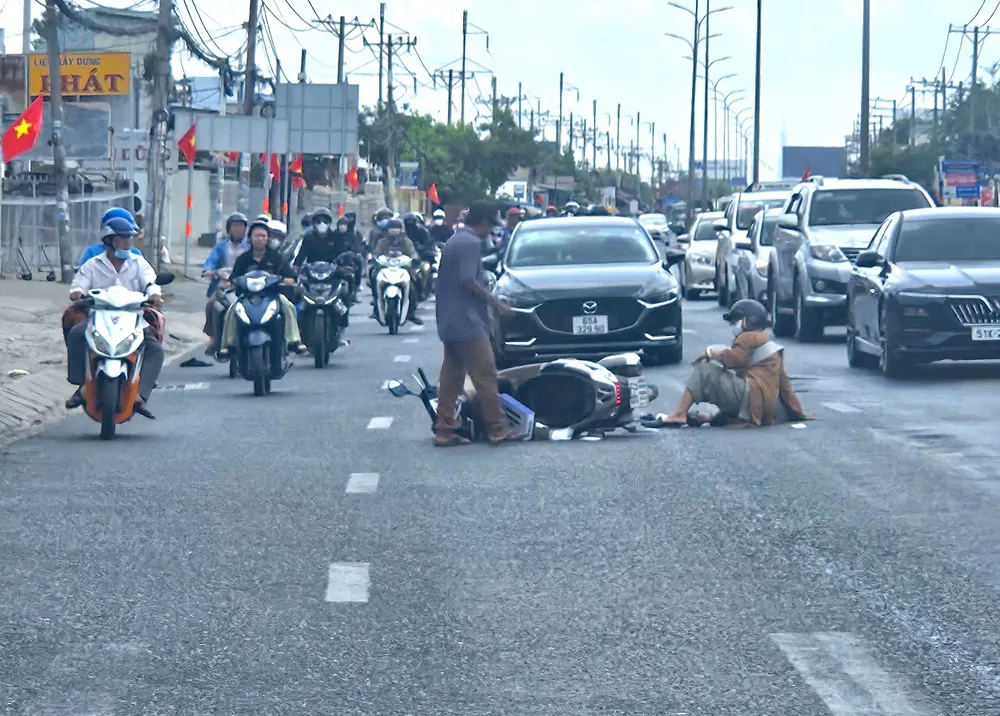 Người dân trượt té vì vệt nhớt, CSGT Tân Túc dang nắng rải cát xuống đường