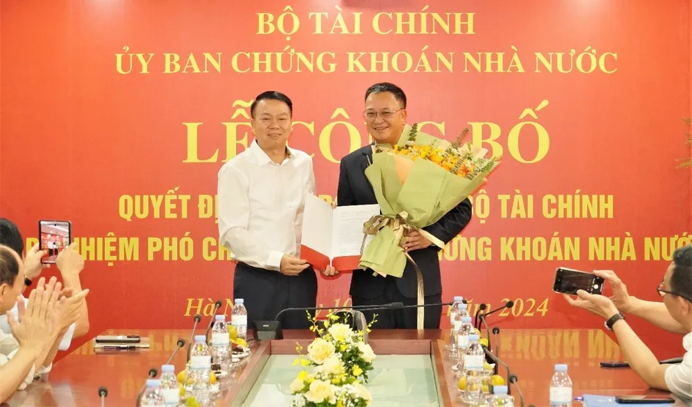 Lãnh đạo Bộ Tài chính trao Quyết định của Bộ trưởng Bộ Tài chính về việc bổ nhiệm Phó Chủ tịch Uỷ ban Chứng khoán Nhà nước đối với ông Bùi Hoàng Hải. Ảnh: VGP uy-ban-chung-khoan-nha-nuoc.jpeg
