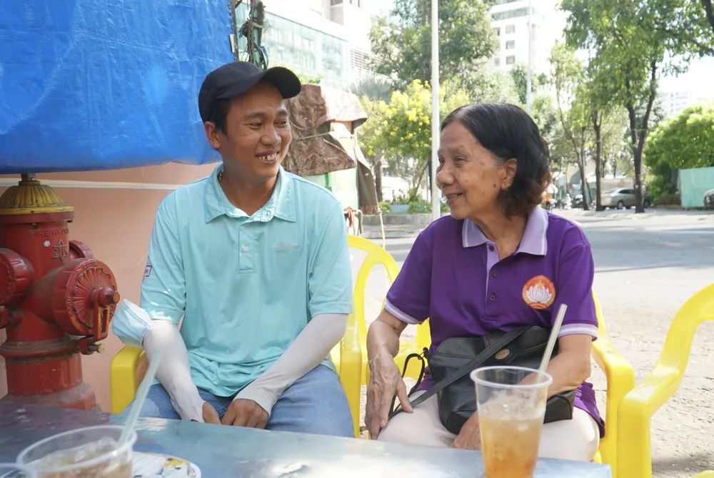 Bà Nguyễn Thị Phương, Trưởng ban Công tác Mặt trận Khu phố 1 (phường 9, quận 4) thăm hỏi anh Trương Minh Tấn. Ảnh: THUẬN VĂN hanh-trinh-10-nam-giup-nhung-nguoi-lam-lo-thay-doi-cuoc-doi-2.JPG