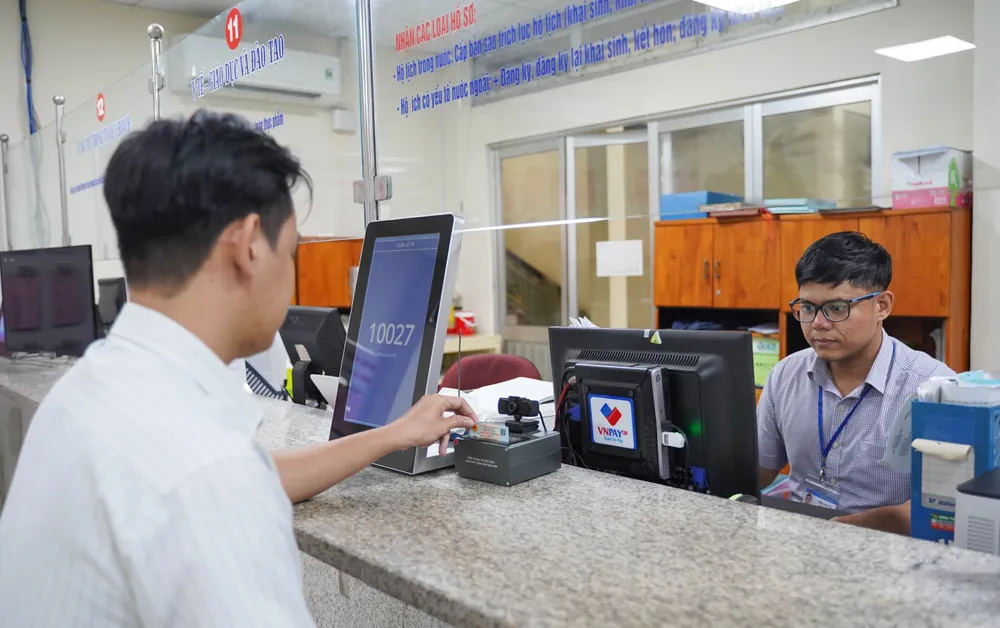 Cán bộ UBND quận Gò Vấp, TP.HCM làm thủ tục hành chính cho người dân. Ảnh: THUẬN VĂN Gắn sắp xếp 80 phường ở TP.HCM với tổ chức chính quyền đô thị