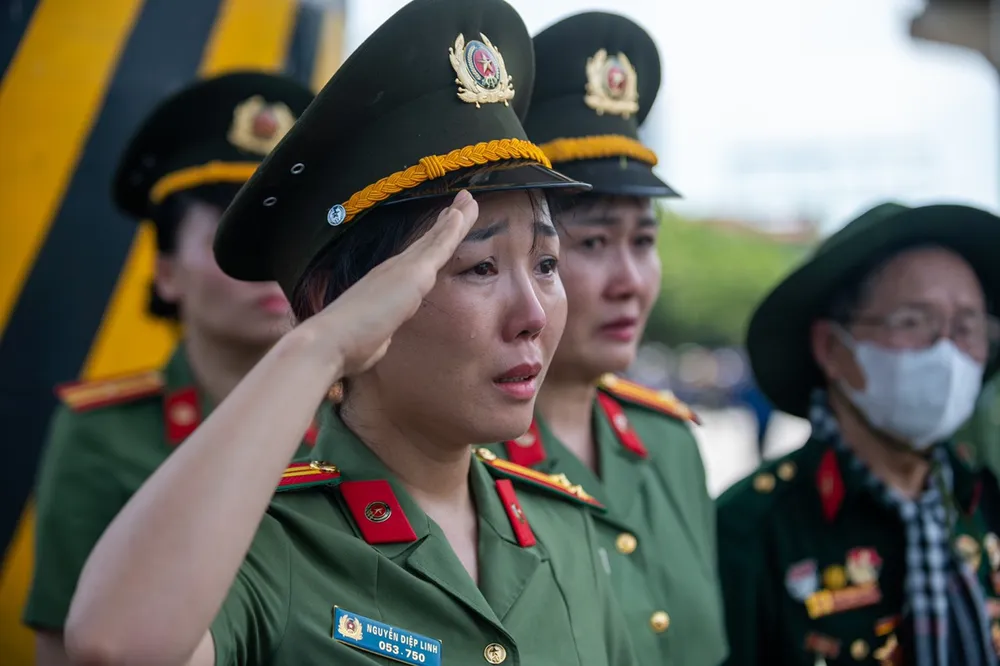 Một nữ chiến sĩ công an không kìm được nước mắt, giơ tay chào Tổng Bí thư Nguyễn Phú Trọng một lần cuối trước khi ông về với đất mẹ. Ảnh: MINH TRÚC tong-bi-thu-nguyen-phu-trong.jpg