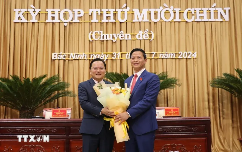 Bí thư Tỉnh ủy Bắc Ninh Nguyễn Anh Tuấn (bên trái) tặng hoa chúc mừng Chủ tịch UBND tỉnh khóa XIX, nhiệm kỳ 2021-2026 Vương Quốc Tuấn. Ảnh: TTXVN Bắc Ninh có Chủ tịch UBND tỉnh 47 tuổi