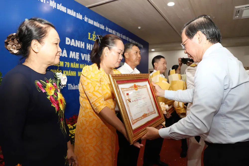 Chủ tịch UBND TP.HCM Phan Văn Mãi chúc mừng thân nhân của các Mẹ Việt Nam anh hùng. Ảnh: HÀ THƯ TP.HCM đang chăm sóc, phụng dưỡng 69 Bà Mẹ Việt Nam anh hùng