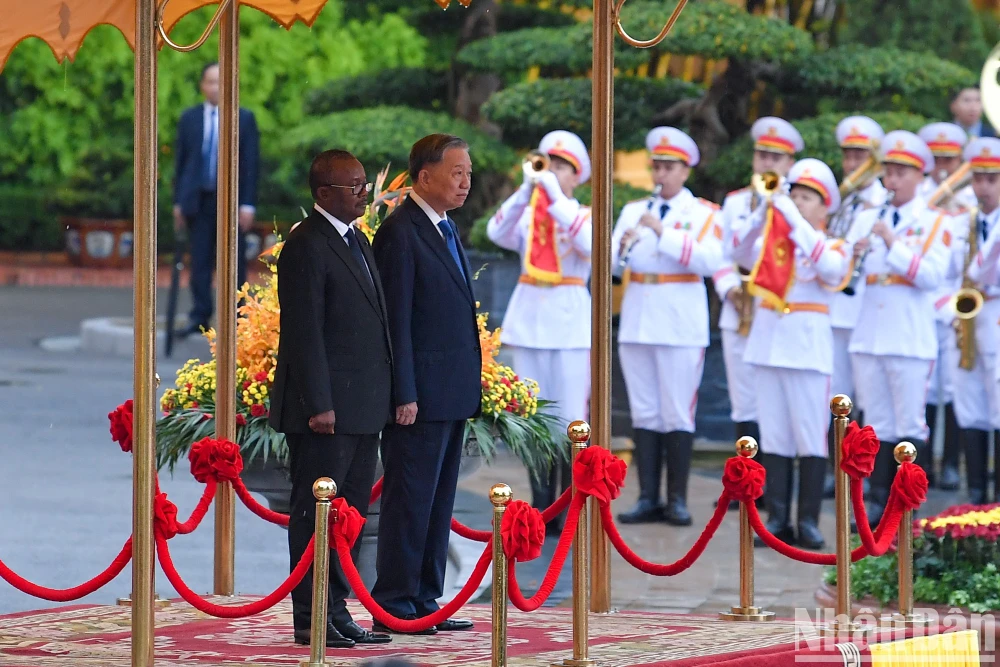 Tổng Bí thư, Chủ tịch nước Tô Lâm và Tổng thống Cộng hòa Guinea-Bissau Umaro Sissoco Embaló trên bục danh dự, nghe quân nhạc cử Quốc thiều hai nước. Ảnh: BÁO NHÂN DÂN tong-bi-thu-chu-tich-nuoc-to-lam-chu-tri-le-don-hoi-dam-voi-tong-thong-guinea-bissau-1.jpg