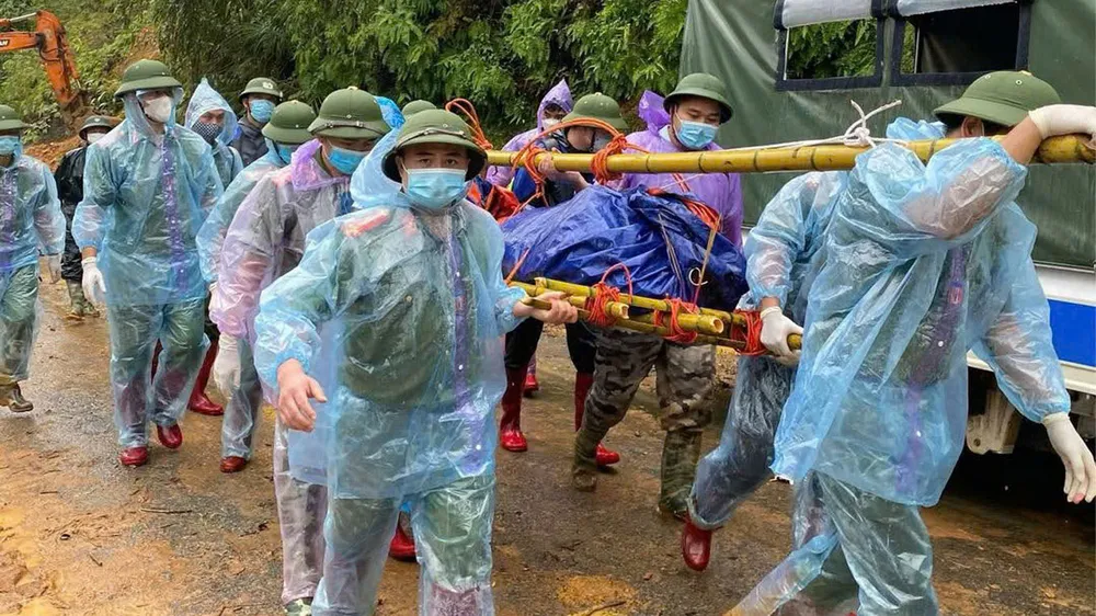 Các chiến sĩ công an phải khiêng thi thể nạn nhân đi bộ hơn 20 km về huyện Nguyên Bình để bàn giao cho gia đình. Ảnh: CTV Xe khách 29 chỗ bị lũ cuốn trôi ở Cao Bằng: Đã tìm thấy 38 thi thể