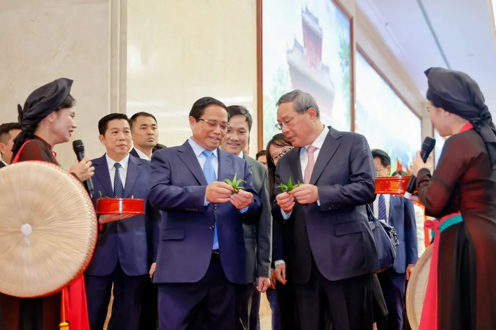 Trong làn điệu đằm thắm, mượt mà của bài quan họ "Mời nước mời trầu", các nghệ sĩ Quan họ Bắc Ninh đã giới thiệu và mời hai Thủ tướng, các đoàn viên "trầu cánh phượng". Ảnh: VGP 2-thu-tuong-viet-nam-trung-quoc-cung-lam-tranh-dong-ho-thuong-lam-dan-ca-quan-ho-2.jpg
