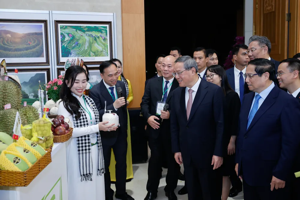 Thủ tướng Phạm Minh Chính và Thủ tướng Lý Cường tham quan trưng bày một số sản phẩm nông nghiệp đặc sắc của Việt Nam xuất khẩu sang Trung Quốc. Ảnh: VGP 2-thu-tuong-viet-nam-trung-quoc-cung-lam-tranh-dong-ho-thuong-lam-dan-ca-quan-ho-8.jpg