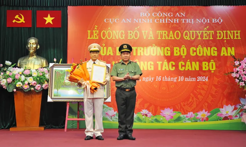 Thiếu tướng Đinh Văn Nơi trao quyết định của Bộ trưởng Bộ Công an về việc điều động Đại tá Hoà Quang Tưng giữ chức vụ Phó cục trưởng Cục An ninh chính trị nội bộ. Ảnh: VGP Đại tá Hòa Quang Tưng làm phó cục trưởng Cục An ninh chính trị nội bộ
