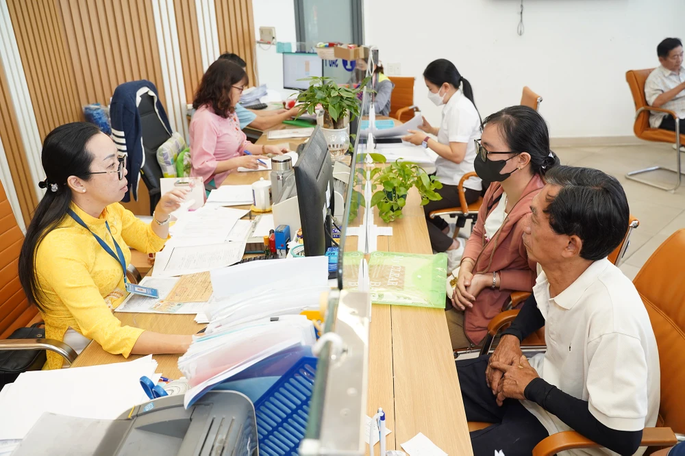 Cán bộ tại bộ phận một cửa quận 5, TP.HCM đang giải quyết thủ tục hành chính cho người dân. Ảnh: THUẬN VĂN giai-bai-toan-ve-nang-luc-can-bo-cap-xa-sau-khi-bo-cap-huyen.JPG