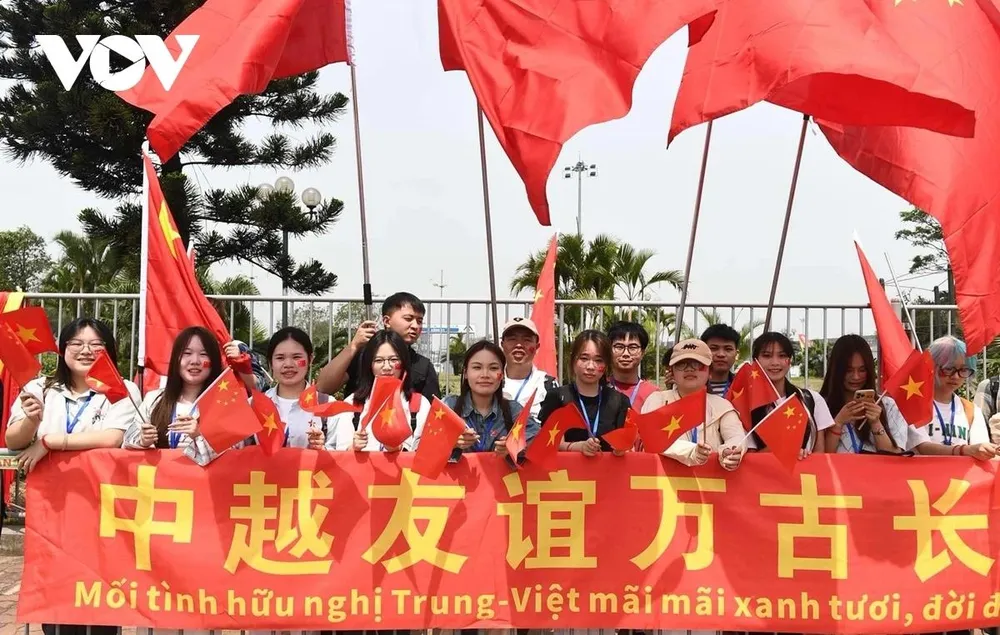 Các bạn sinh viên cầm cờ hai nước chào đón đoàn Tổng Bí thư, Chủ tịch Trung Quốc Tập Cận Bình. Ảnh: VOV don-tong-bi-thu-chu-tich-nuoc-trung-quoc-tap-can-binh-tai-san-bay-noi-bai-tham-viet-nam-1.jpg