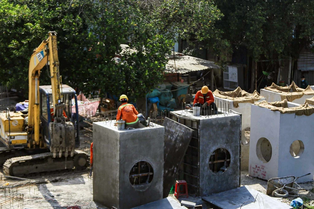 Các công nhân đang tích cực làm việc tại công trường dự án. Ảnh NGUYỄN CHÂU