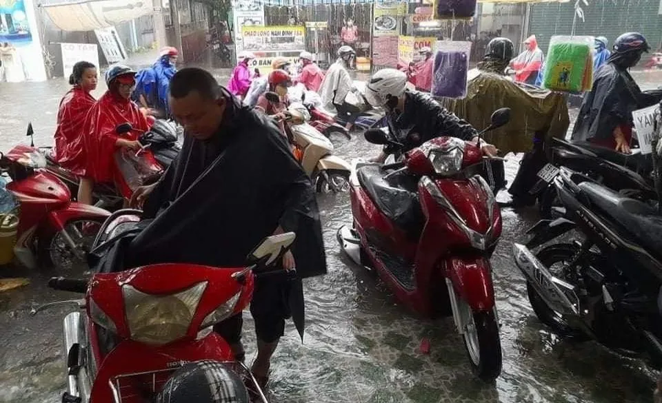 Người dân phải dừng xe trú mưa. Ảnh: TUYẾT TRINH