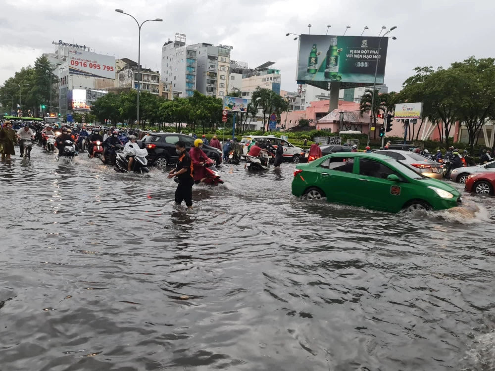 Tạnh mưa nhưng nước vẫn ngập hơn nửa bánh xe. Ảnh: NGUYỄN CHÂU