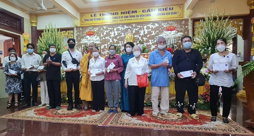 Trao quà cho các gia đình có người thân mất do COVID-19 gặp khó khăn. Ảnh: NV