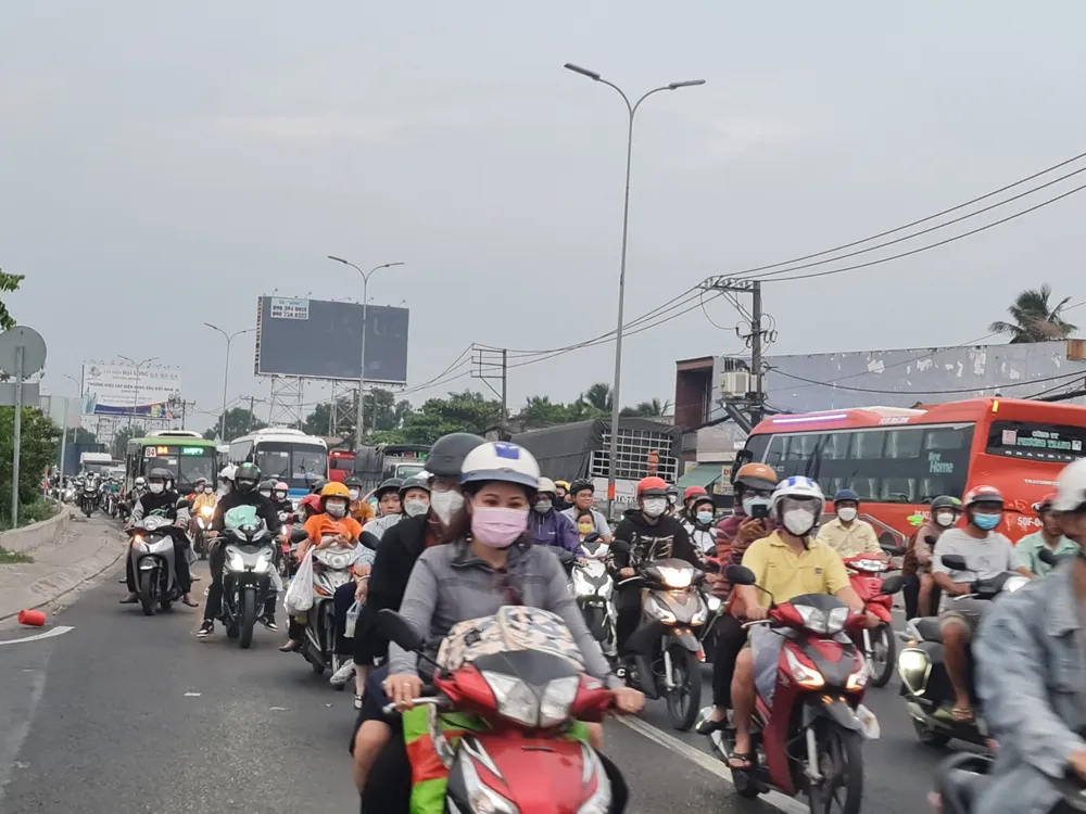 Lượng người lưu thông tại giao lộ Quốc lộ 1A – đường Nguyễn Hữu Trí Huyện Bình Chánh. Ảnh: NGUYỄN CHÂU