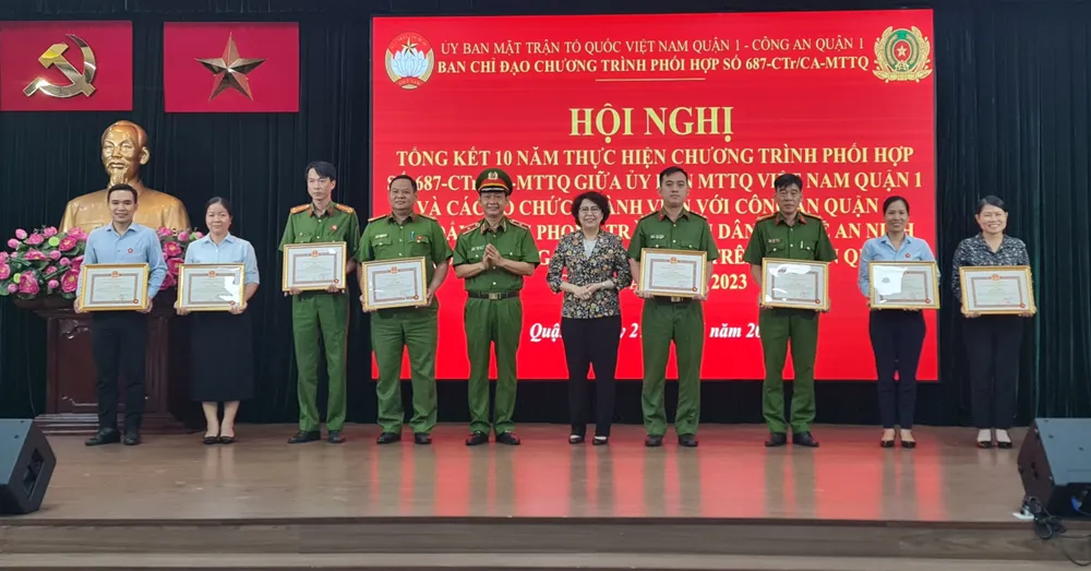 Lãnh đạo công an TP và lãnh đạo UBND quận 1 trao giấy khen cho những cá nhân, tập thể có thành tích xuất sắc trong 10 năm thực hiện Chương trình phối hợp số 687-CTr/CA-MTTQ. Ảnh: NC