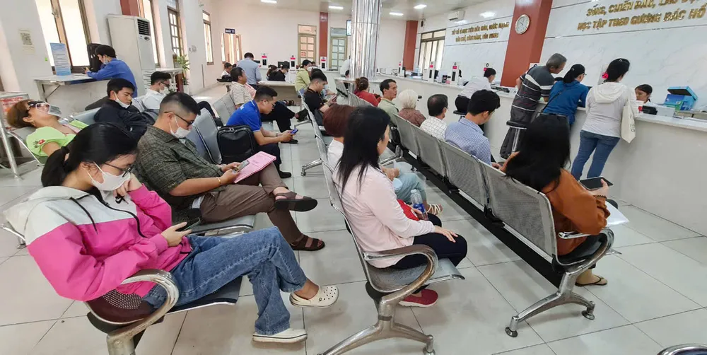 Người dân chờ làm thủ tục ở Chi nhánh Văn phòng đăng ký đất đai quận Tân Bình. Ảnh: NGUYỄN CHÂU hồ sơ đất đai bảng giá đất tân bình.jpg