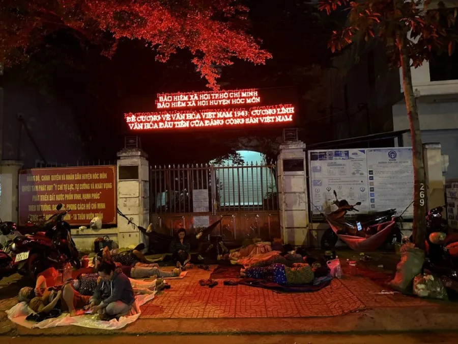 Gần 2 giờ sáng, ngày 7-4, khoảng 30 người đã có mặt trước cổng trụ sở Bảo hiểm xã hội huyện Hóc Môn (TP.HCM) chờ rút tiền bảo hiểm xã hội (BHXH) một lần. Ảnh: TRẦN MINH