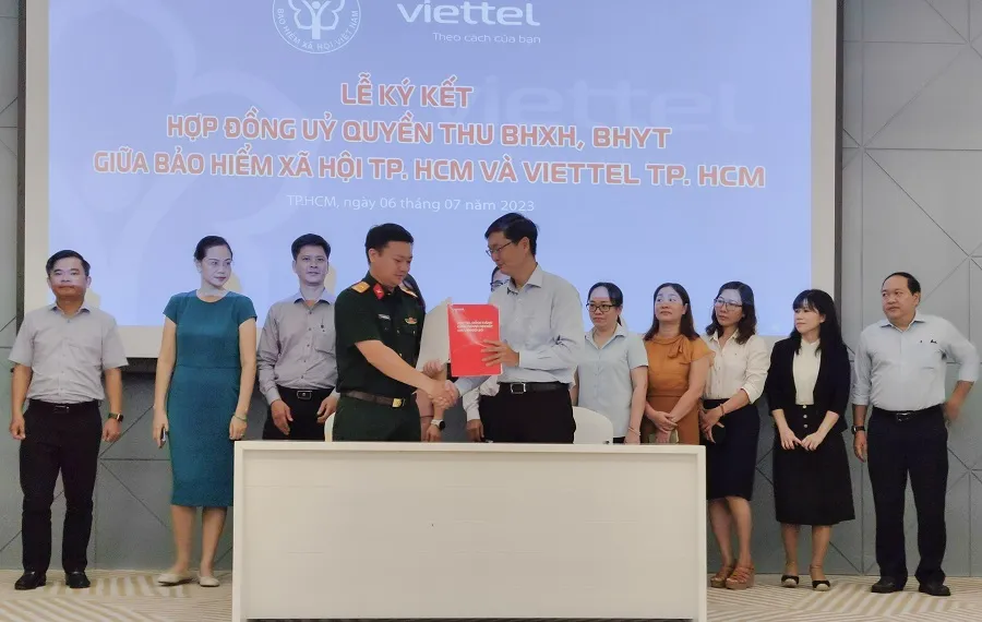 Đại diện BHXH và Viettel TP.HCM ký hợp đồng ủy quyền thu BHXH tự nguyện, BHYT hộ gia đình. Ảnh: NGUYỄN HIỀN