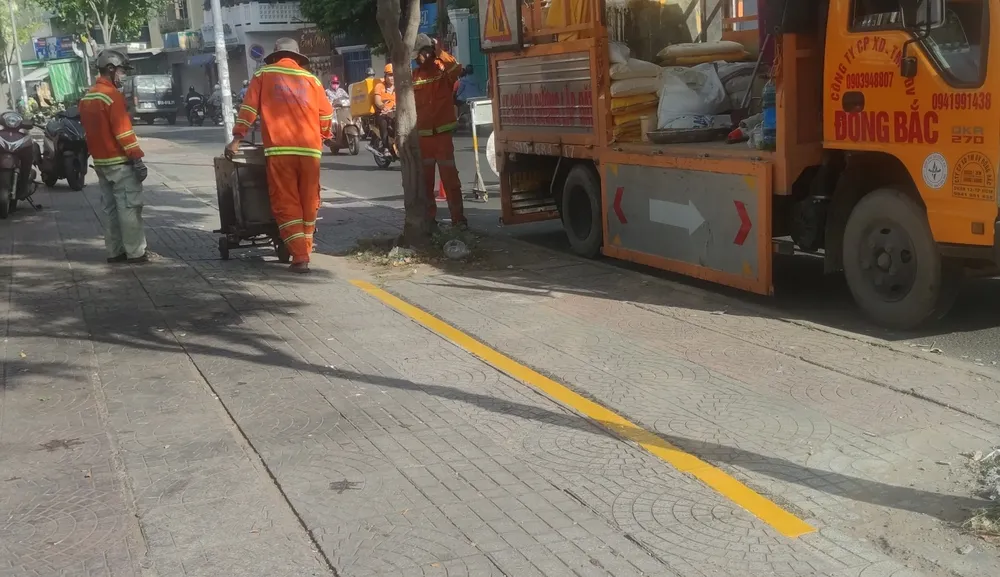 Các công nhân đang thực hiện kẻ vạch sơn trên vỉa hè tuyến đường Trần Đình Xu. Ảnh: NGUYỄN HIỀN ke vach son su dung via he tam h2.jpg