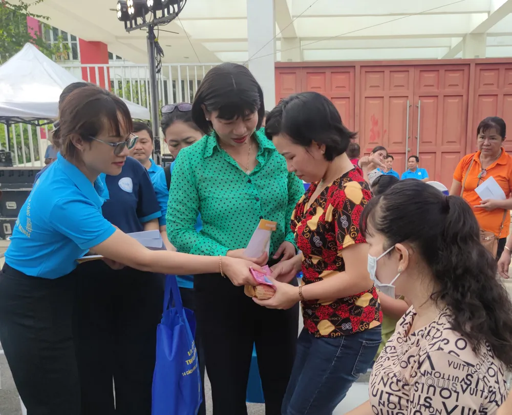 Bà Trần Thị Phương Hoa, Phó Chủ tịch Hội LHPN TP.HCM ( mặc áo sơ mi màu xanh) nhận quà cho nữ công nhân trong ngày hội. Ảnh: NGUYỄN HIỀN NU CONG NHAN-H4.jpg