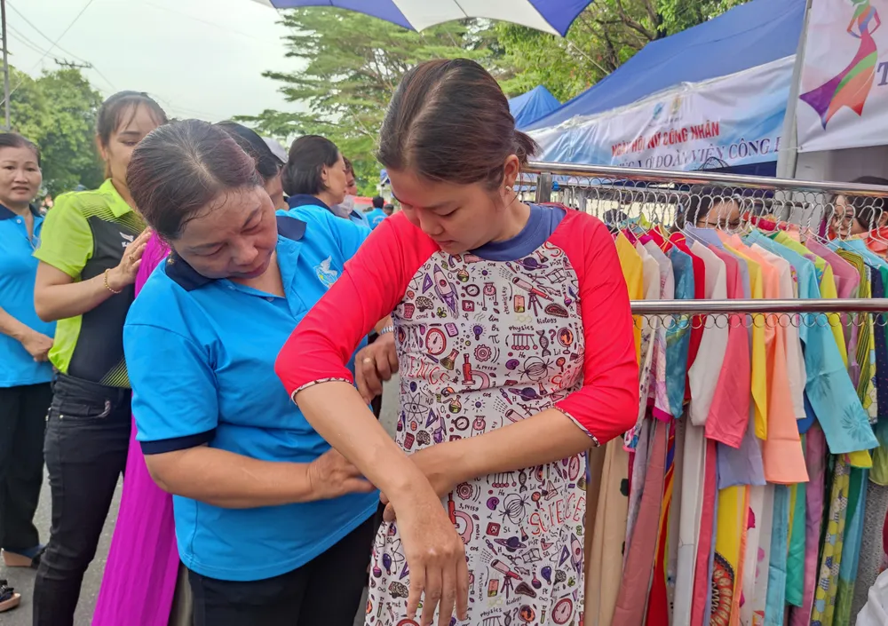 Công nhân thử và nhận áo dài miễn phí trong ngày hội. Ảnh: NGUYỄN HIỀN nữ công nhân