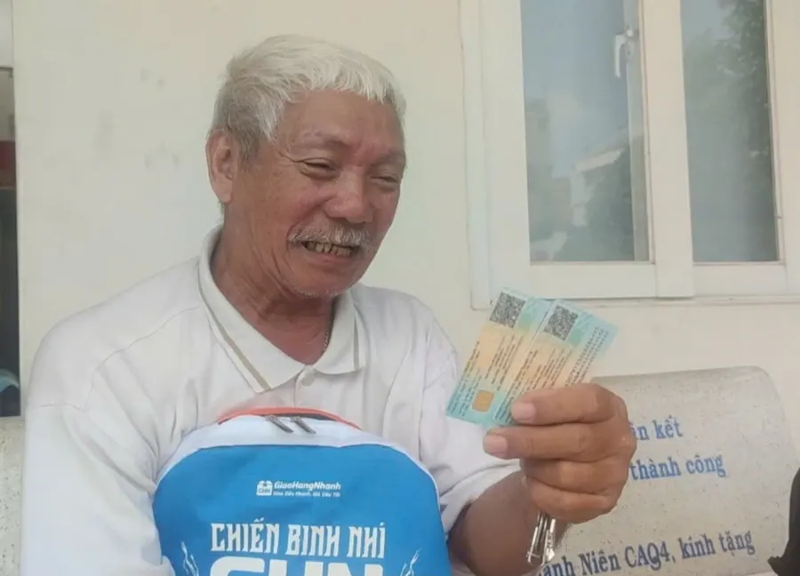 Trước phòng cấp thẻ căn cước của Công an quận 4, cầm trên tay 2 tấm thẻ căn cước, ông Võ Văn Sung khoe sẽ chở vợ qua phường mua thẻ BHYT. Ảnh: NGUYỄN HIỀN the-can-cuoc-h1.jpg