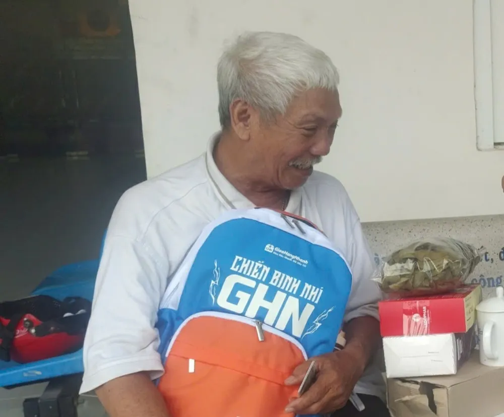 Ông Sung nhận quà của báo gửi tặng đứa cháu nội ông. Ảnh: NGUYỄN HIỀN the-can-cuoc-h2.jpg