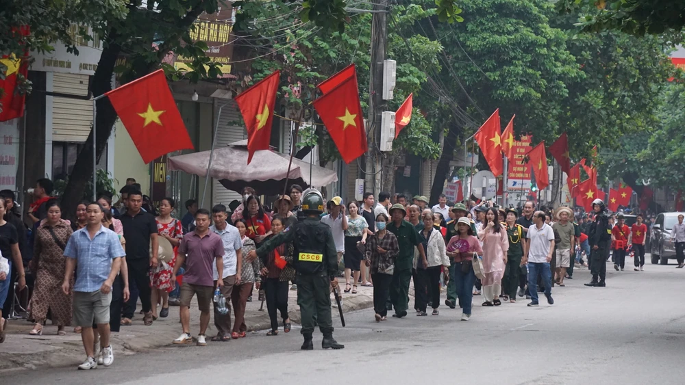 Hình ảnh người dân cùng nhau đi về phía trung tâm thành phố Điện Biên Phủ dưới tiếng nhạc dồn dập, mời gọi như tái hiện vẻ đẹp hành quân, khí thế oai hùng của cha ông ta 70 năm trước trong chiến thắng Điện Biên Phủ. Ảnh XUÂN NGUYỄN Thành công của Lễ kỷ niệm 70 năm chiến thắng Điện Biên Phủ từ âm thanh loa phường 22.JPG