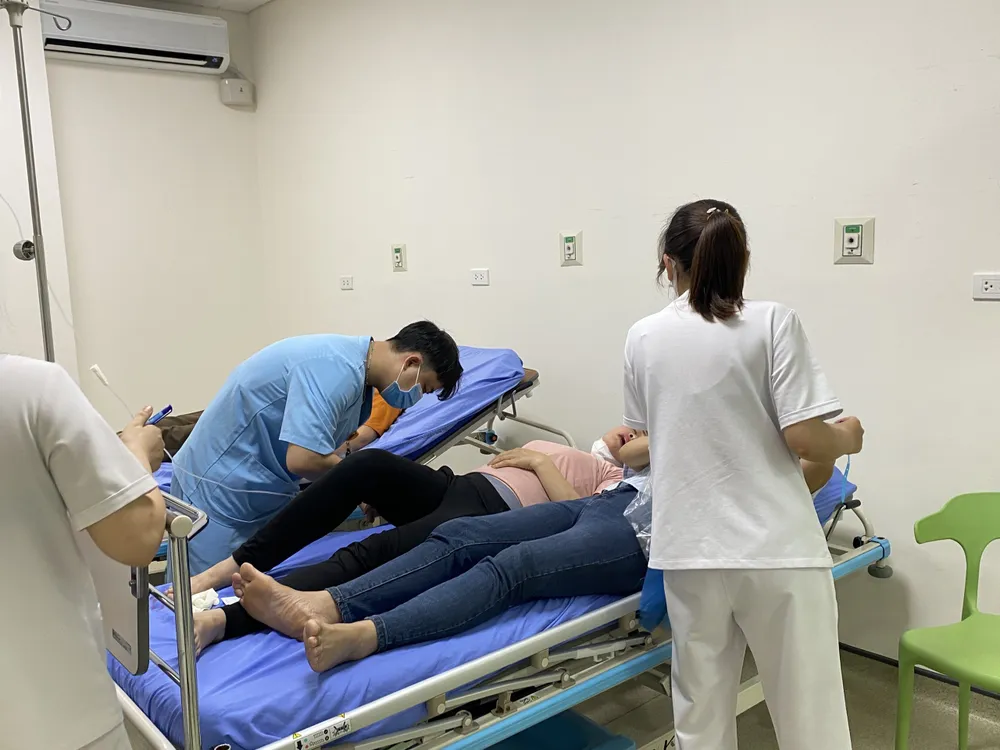 Các công nhân Công ty TNHH Shinwon Ebenezer Việt Nam, chuyên về may mặc đang được cấp cứu. Ảnh CTV Cấp cứu hàng trăm công nhân nghi ngộ độc thực phẩm ở Vĩnh Phúc.jpg
