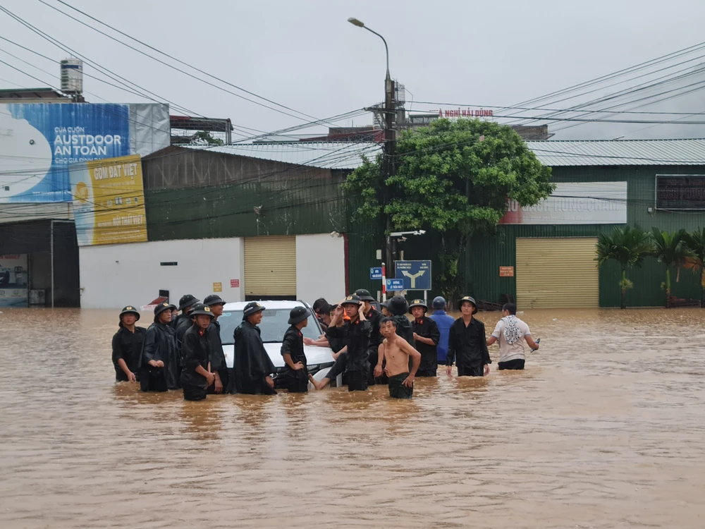 Lực lượng công an cùng người dân di dời tài sản. Ảnh CTV Ba người chết do mưa lũ ở Hà Giang.jpg