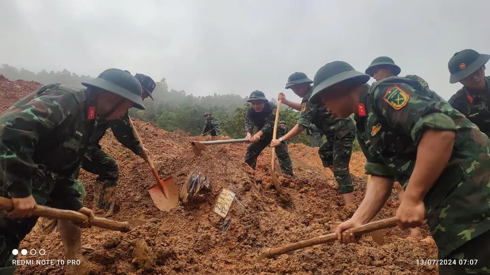 Cán bộ chiến sĩ thuộc Bộ chỉ huy quân sự tỉnh Hà Giang tham gia cứu hộ. Ảnh: QUỐC HOÀN Ảnh Hiện trường sạt lở đất đá vào xe 16 chỗ ở Hà Giang 3.jpg