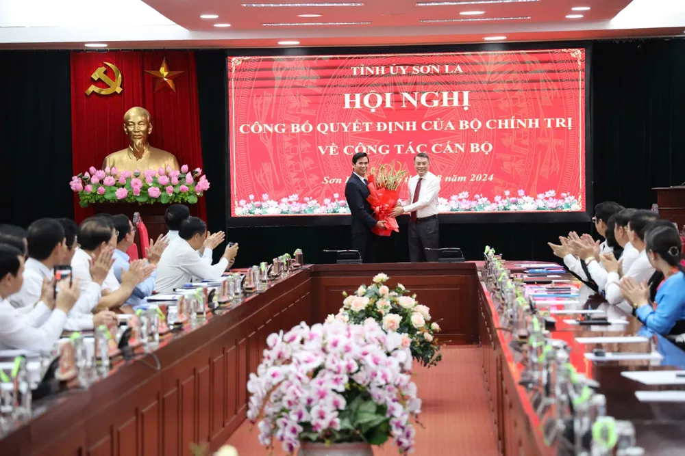 Ông Lê Minh Hưng, Trưởng Ban Tổ chức Trung ương trao quyết định, tặng hoa chúc mừng ông Hoàng Quốc Khánh. Ảnh: XUÂN NGUYỄN Ông Hoàng Quốc Khánh làm bí thư tỉnh sơn la.JPG