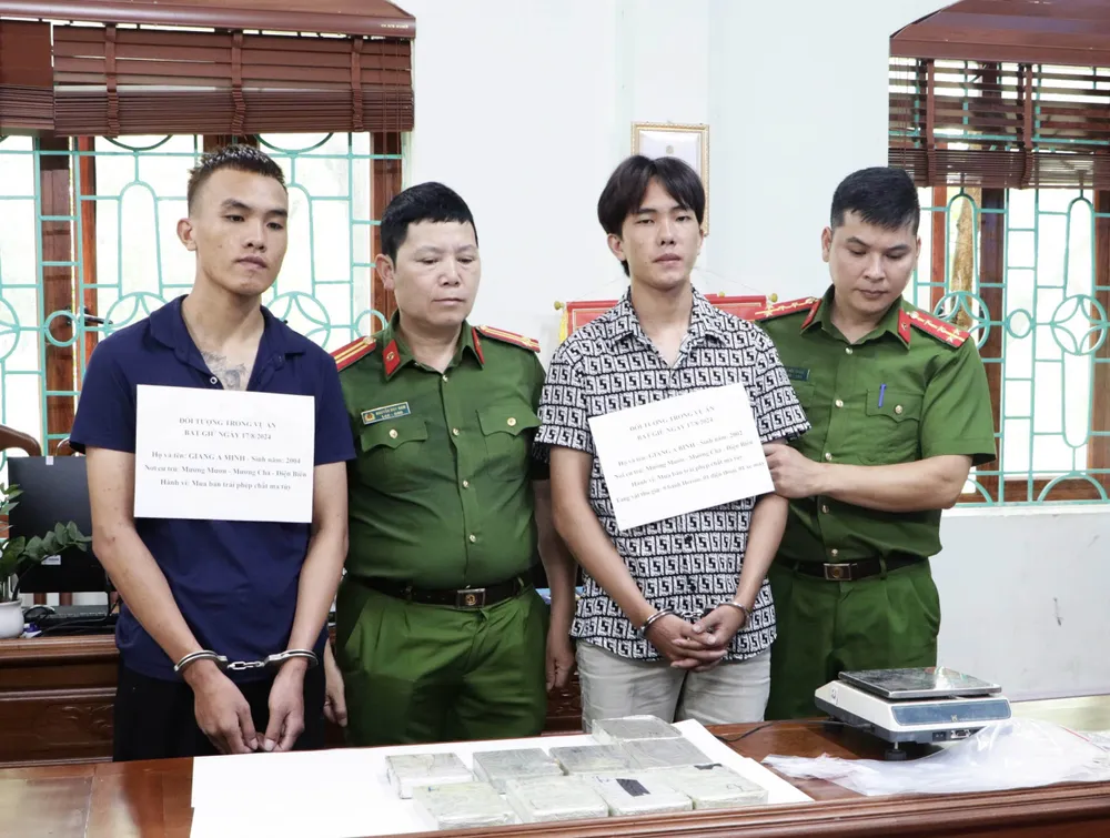 Hai anh em Bình và Minh cùng tang vật vụ án. Ảnh CA Bắt kẻ vận chuyển 9 bánh heroin.jpg