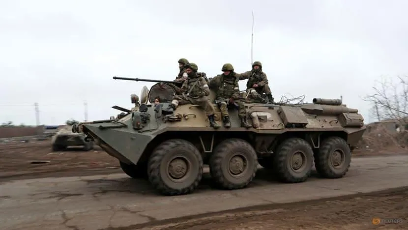 Quân đội Nga đi trên một xe bọc thép ở Mariupol, Ukraine, ngày 12-4. Ảnh: REUTERS