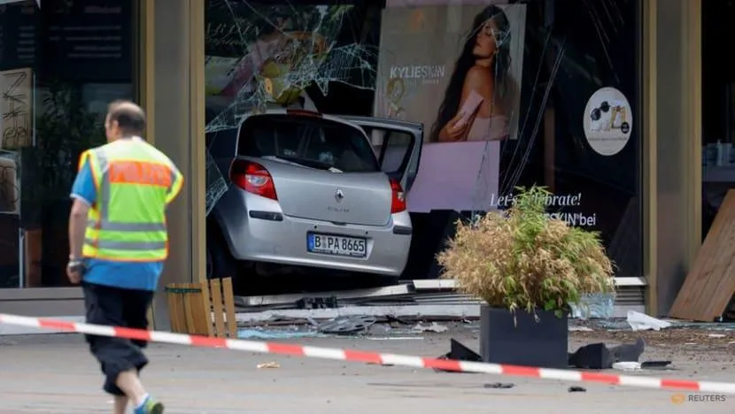 Chiếc xe hơi màu bạc chỉ dừng lại sau khi đâm xuyên qua cửa kính của một cửa hàng. Ảnh: REUTERS Chiếc xe hơi màu bạc chỉ dừng lại sau khi đâm xuyên qua cửa kính của một cửa hàng. Ảnh: REUTERS