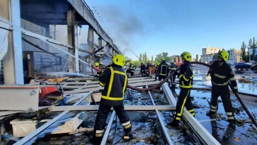 Lực lượng cứu hộ dập tắt đám cháy bùng phát tại trung tâm mua sắm bị Nga không kích ở TP Kremenchuk, vùng Poltava, Ukraine, ngày 27-6. Ảnh: REUTERS