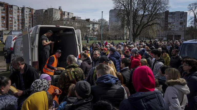 Người dân nhận viện trợ nhân đạo trong sân một trường học ở TP Chernihiv, phía bắc Ukraine. Ảnh: AP