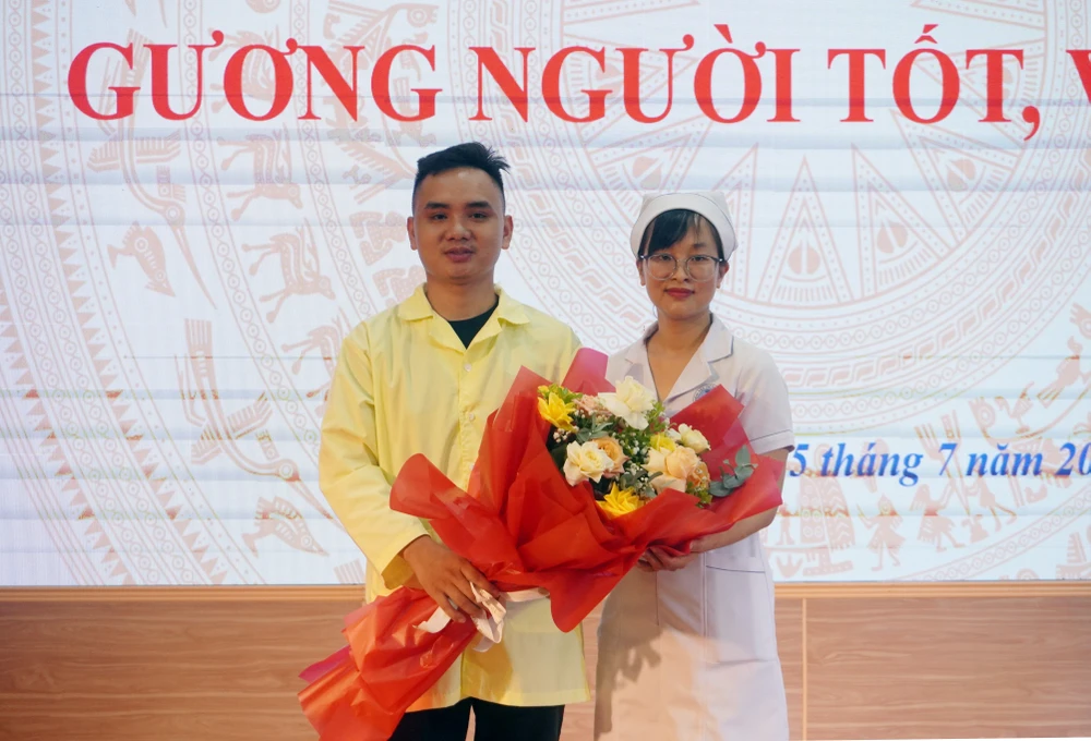 Anh Hoàng Văn Tuyền, bố cháu bé tặng hoa cảm ơn nữ điều dưỡng Nguyễn Thị Thảo - người mà gia đình anh coi như người mẹ thứ 2 của cháu bé. Ảnh: NGỌC SƠN nu-dieu-duong-va-15-phut-sinh-tu-cuu-song-em-be-so-sinh-bi-sac-sua-ngung-tim-.JPG