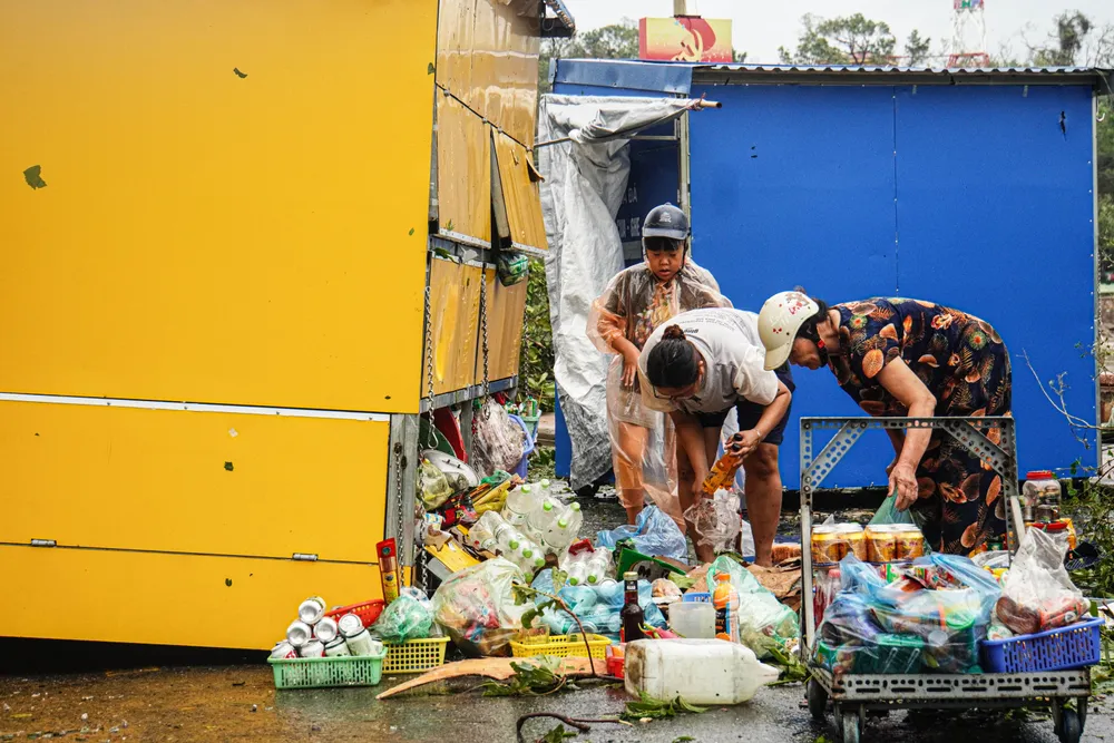 Bà Lương Thị Phi, người dân ở tổ 2 phường Vạn Hương đang thu dọn Kios sau khi Kios của bà bị bão số 3 quật bay. 'Gần 70 năm sinh sống ở đây, đây là lần đầu tiên tôi thấy có cơn bão mạnh và kéo dài như vậy. Bão đi kèm với gió giật liên tục trong khoảng 6-7 giờ đồng hồ' - bà Phi nói. Ảnh: NGỌC SƠN