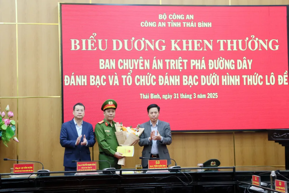 Chủ tịch UBND tỉnh Thái Bình Nguyễn Mạnh Hùng (trái) và Phó Chủ tịch UBND tỉnh Thái Bình Lại Văn Hoàn (phải) khen thưởng, chúc mừng ban chuyên án triệt phá đường dây đánh bạc. Ảnh: NS