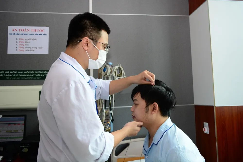 Kỹ thuật viên lắp điện cực não đo đa ký giấc ngủ cho bệnh nhân tại Trung tâm Hô hấp, BV Bạch Mai. Ảnh: BVBM