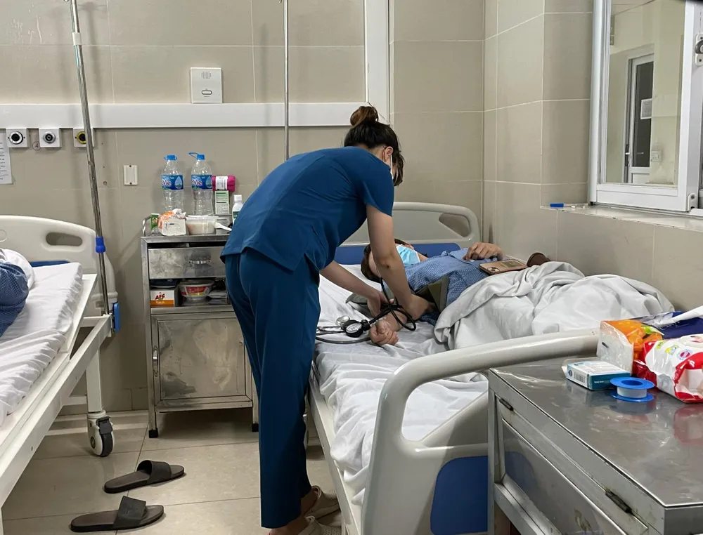 Bác sĩ đang kiểm tra sức khoẻ cho bệnh nhân cúm A. Ảnh: NHƯ LOAN