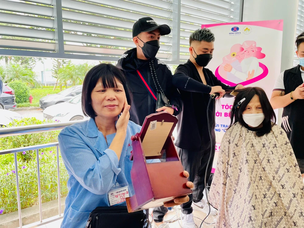 Ngồi cầm ngắm mình trong gương sau khi được tạo mẫu tóc mới, bà Vũ Thị Nga (ngụ tổ 20, thị trấn Đông Anh, Hà Nội) xúc động không kìm được những giọt nước mắt. Ảnh: NHƯ LOAN